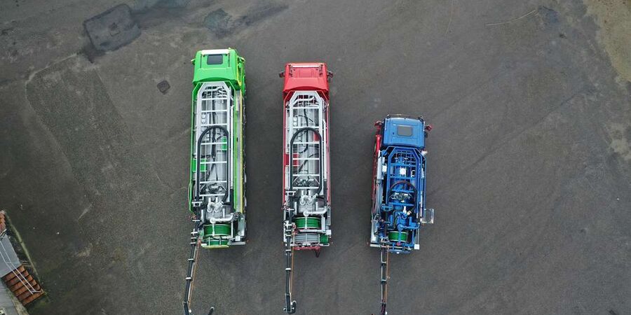 Dronefoto tre slamsuger lastbiler ved siden af hinanden fra en lille model til en stor model